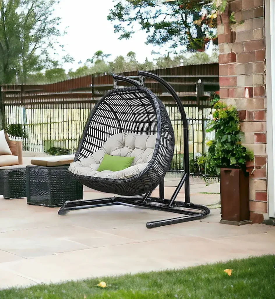 Outdoor hanging egg chair with cushions on patio.