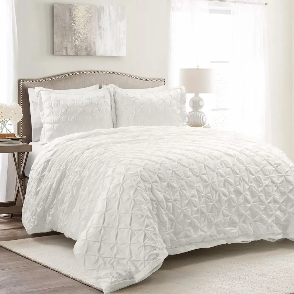 White textured bedding in bright bedroom setting.