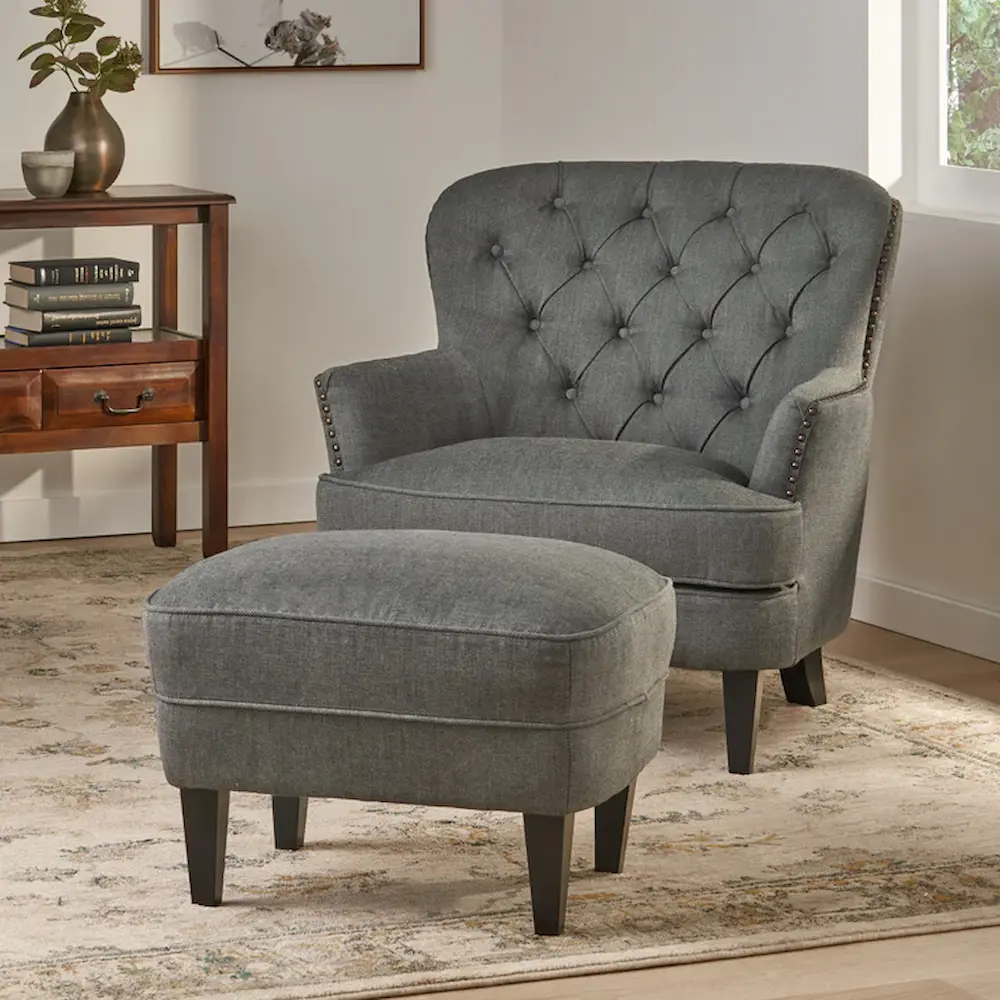 Gray tufted armchair with matching ottoman.