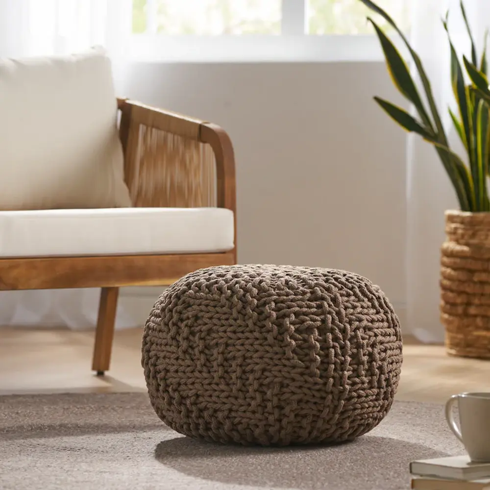 Knitted pouf in cozy living room interior.